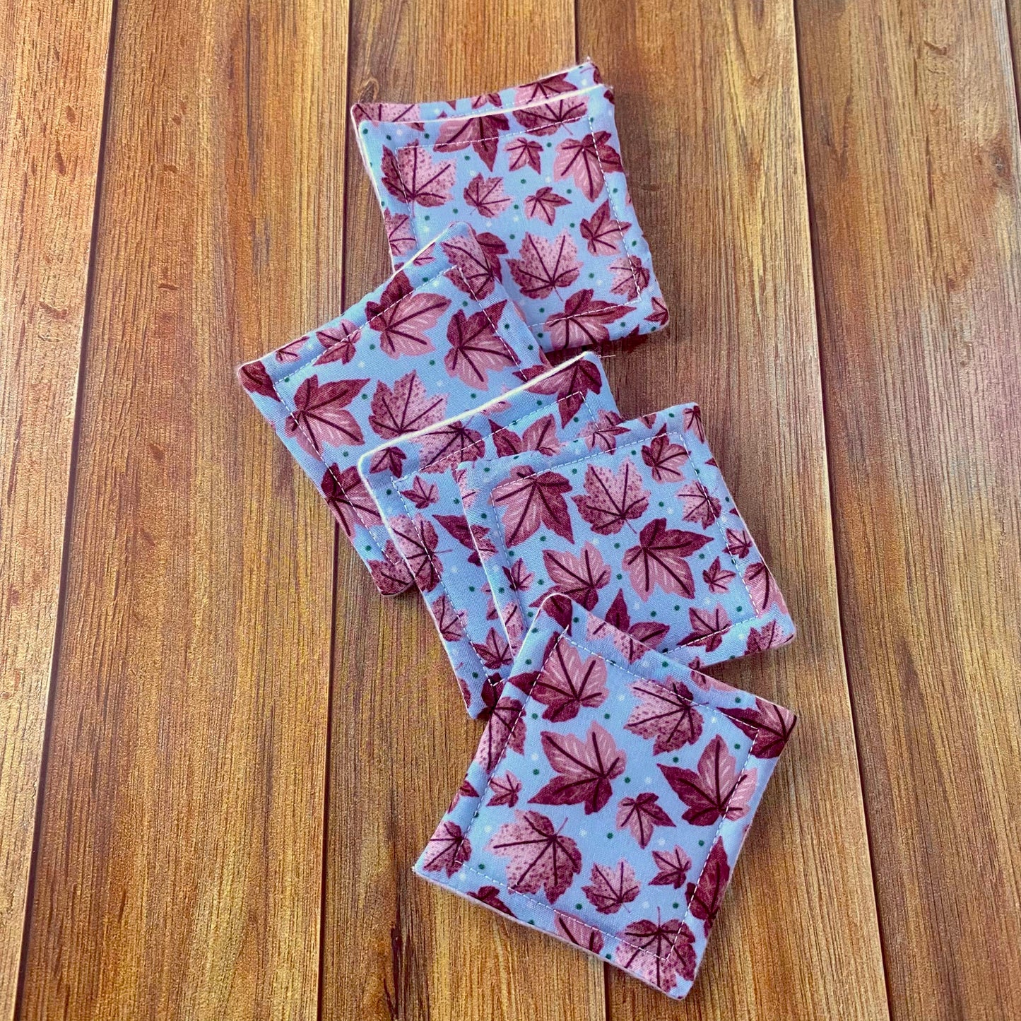 Pink leafy patterned reusable skincare pads on a wooden background