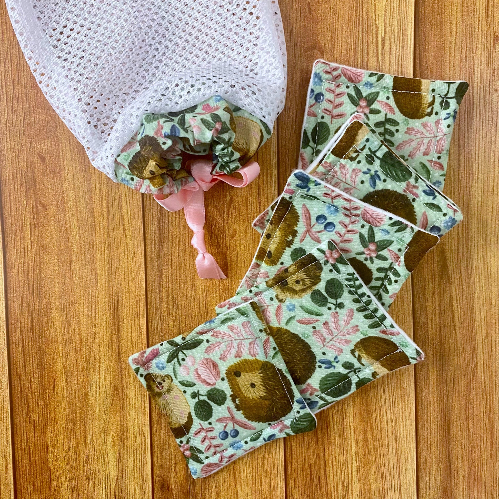 reusable skincare pads and washbag on wooden surface