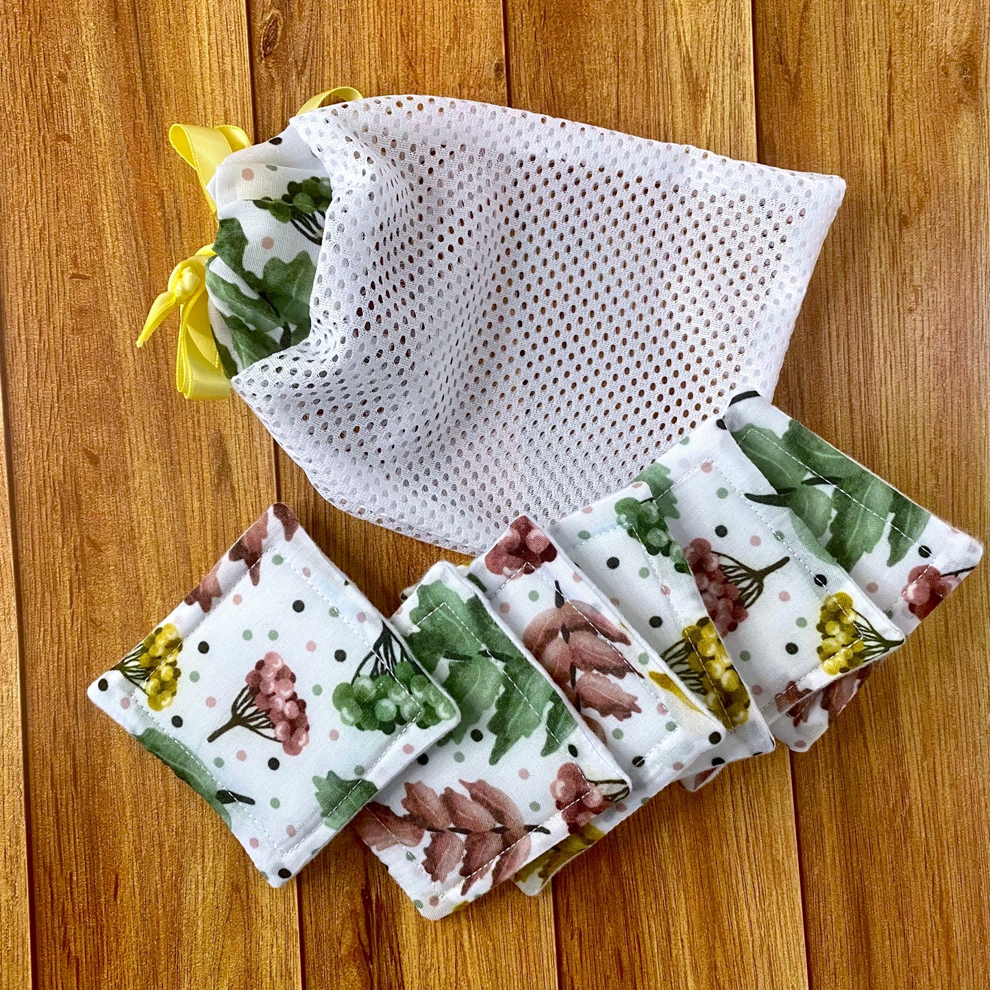 skincare pads and washbag with pretty foliage pattern on them on wooden background