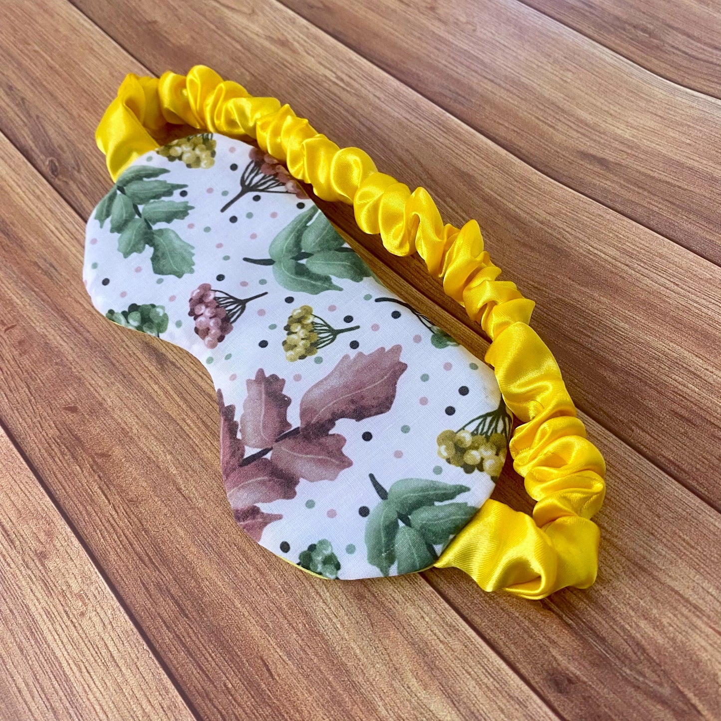 pretty foliage patterned sleepmask on a wooden background