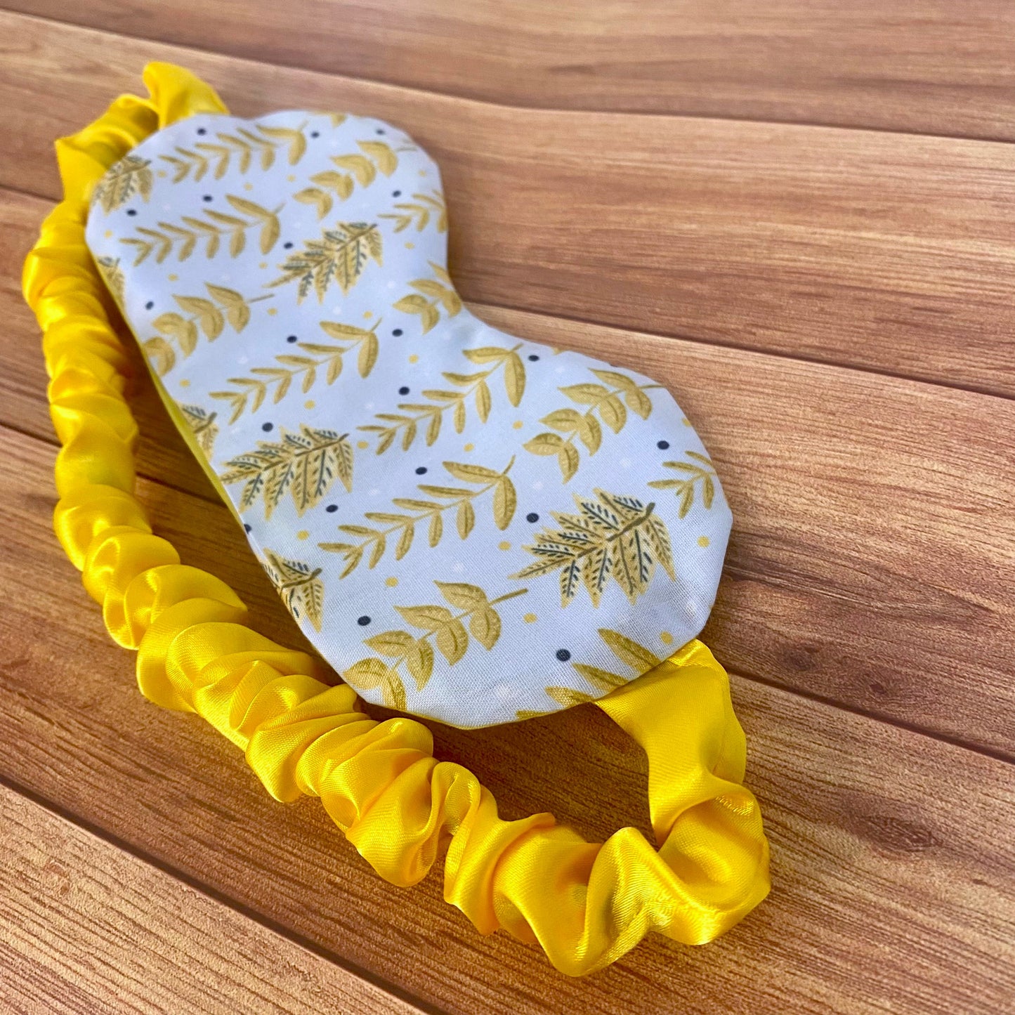 yellow foliage patterned sleepmask on a wooden backdrop