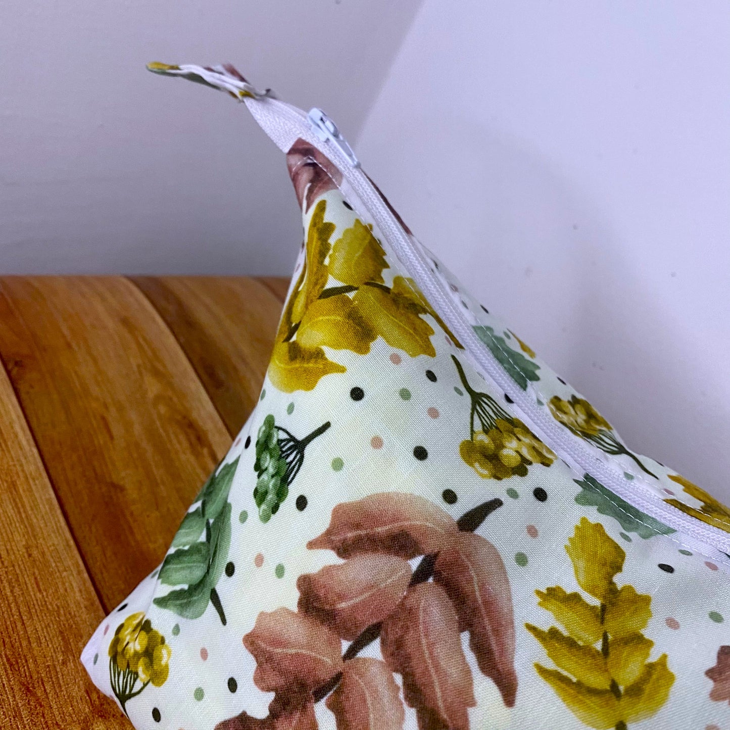 closeup of the pretty foliage patterned makeup bag showing the pattern and the zip.