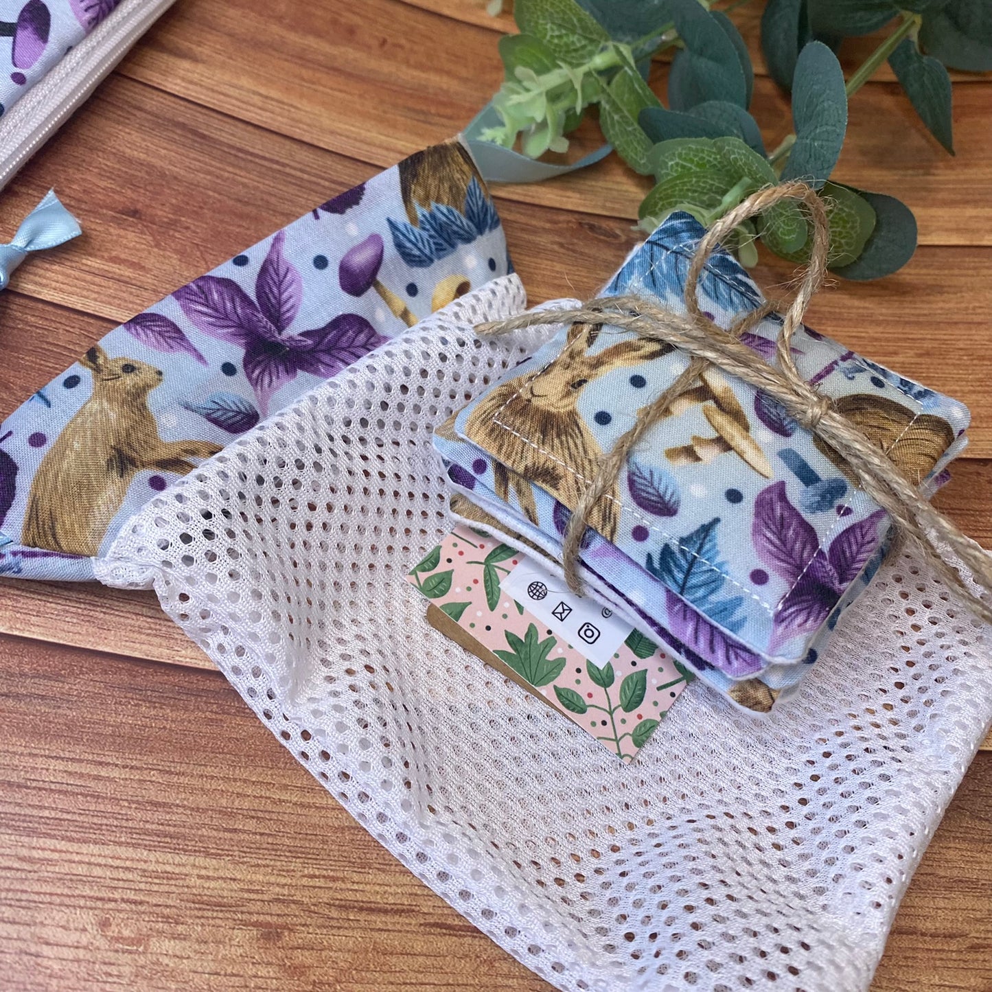 reusable skincare pads and washbag on wooden surface