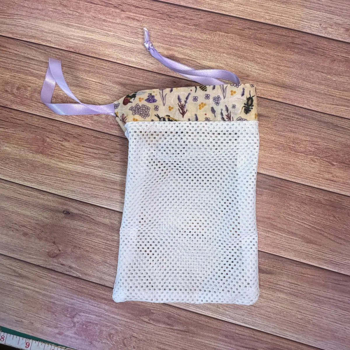 Bee laundry wash bag with a ribbon drawstring for reusable makeup remover pads.
