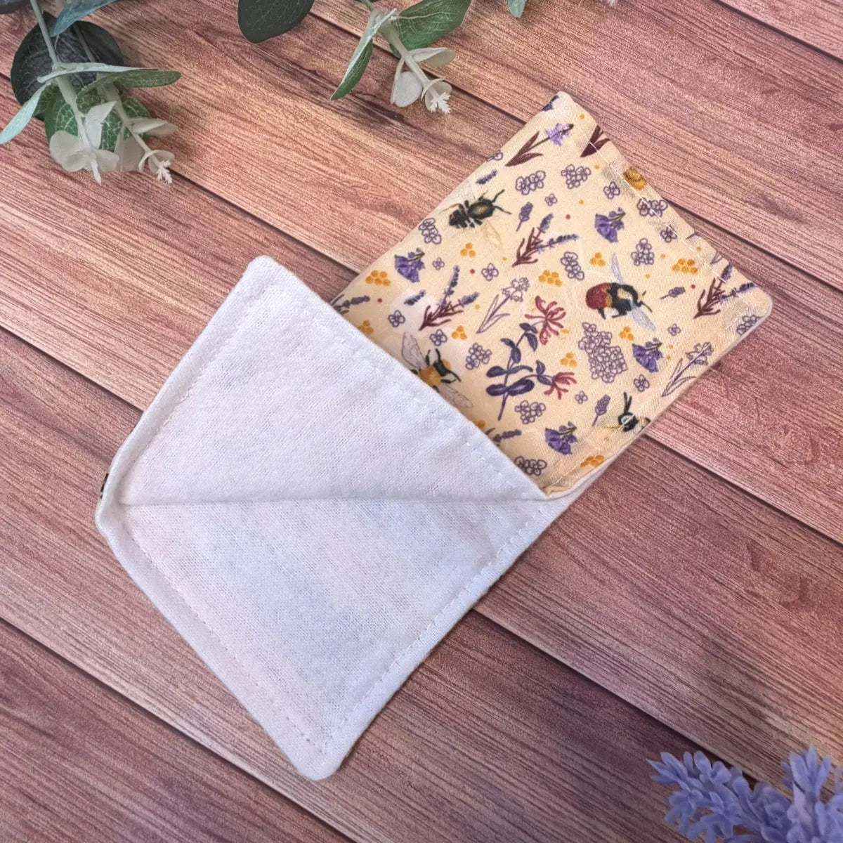 Bee patterned reusable facecloth with a white brushed cotton cleansing surface.
