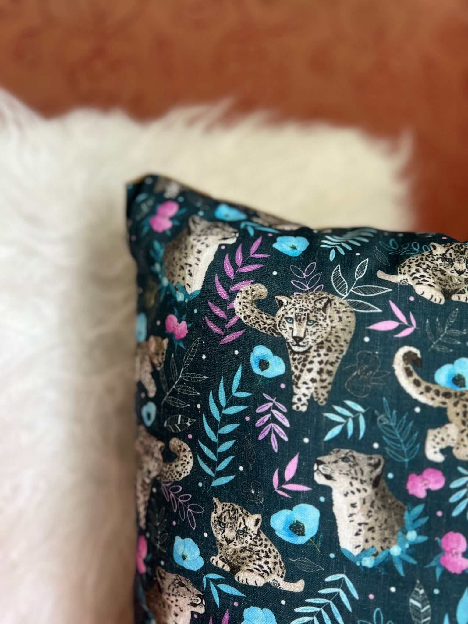 closeup of the snow leopard cushion, a great wild animal gift for someone who loves animals.