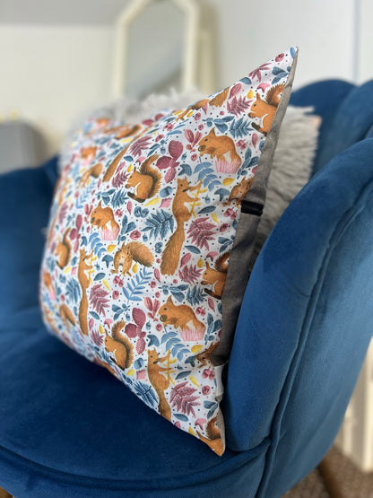 side of the red squirrel decorative cushion for a sofa, this squirrel gift idea is shown sat on a blue armchair