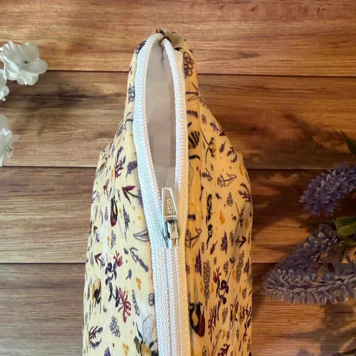 Fabric toiletry bag decorated with a repeating bee pattern.
