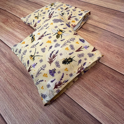 Reusable fabric hand warmers decorated with an original repeating bee design.
