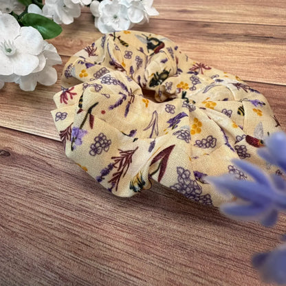 Fabric hair scrunchie decorated with an illustrated bee pattern.
