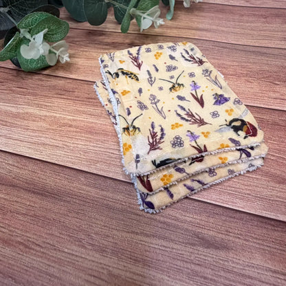 Three handmade exfoliating face pads with original illustrated bee artwork.
