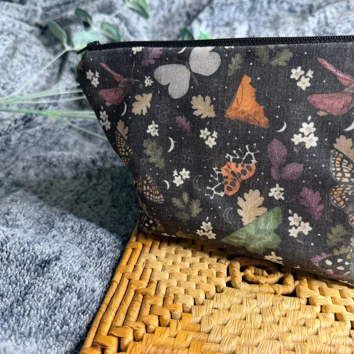 Large moth cosmetic pouch with a dark insect-inspired design, suitable for makeup and skincare essentials.
