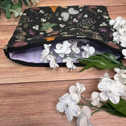 Fabric makeup bag decorated with a repeating moth pattern inspired by the natural world.
