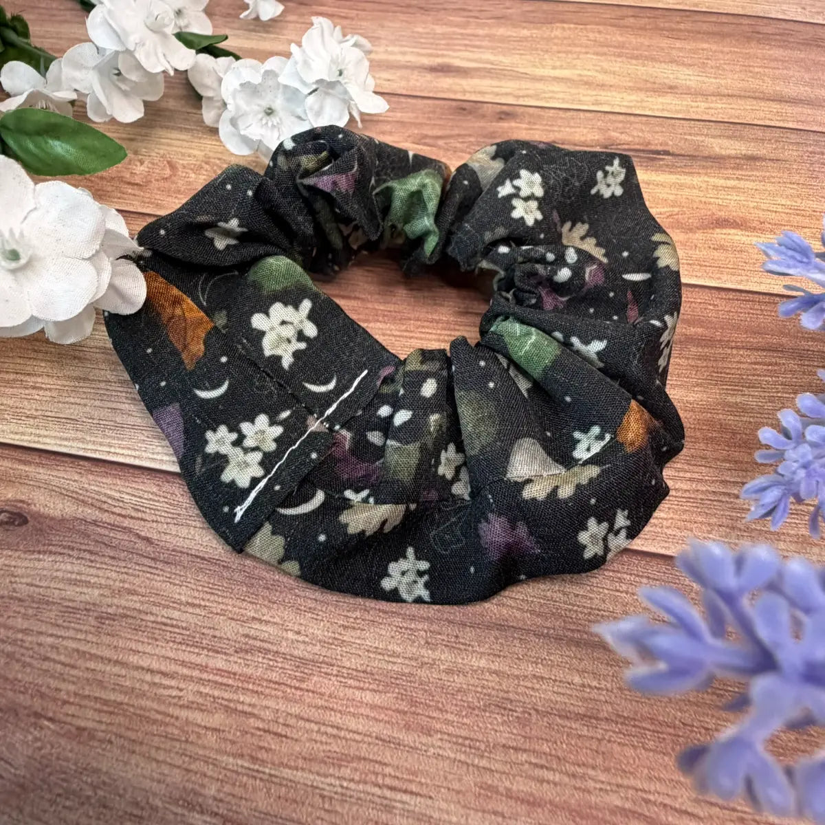 Fabric moth hair scrunchie with a darker illustrated insect pattern.
