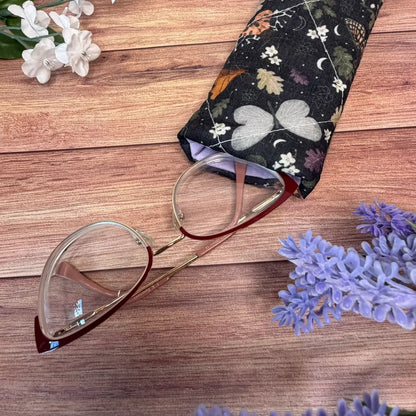 Dark patterned moth glasses case with quilted padding and a hook-and-loop fastening.
