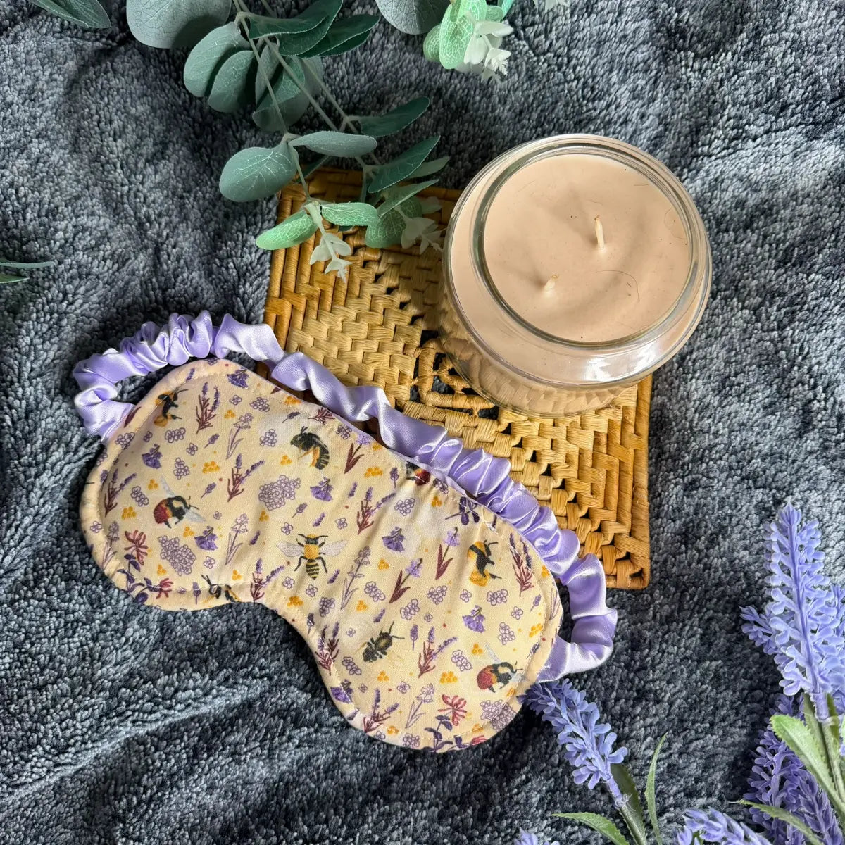 Fabric sleeping eye mask decorated with a repeating bee pattern.
