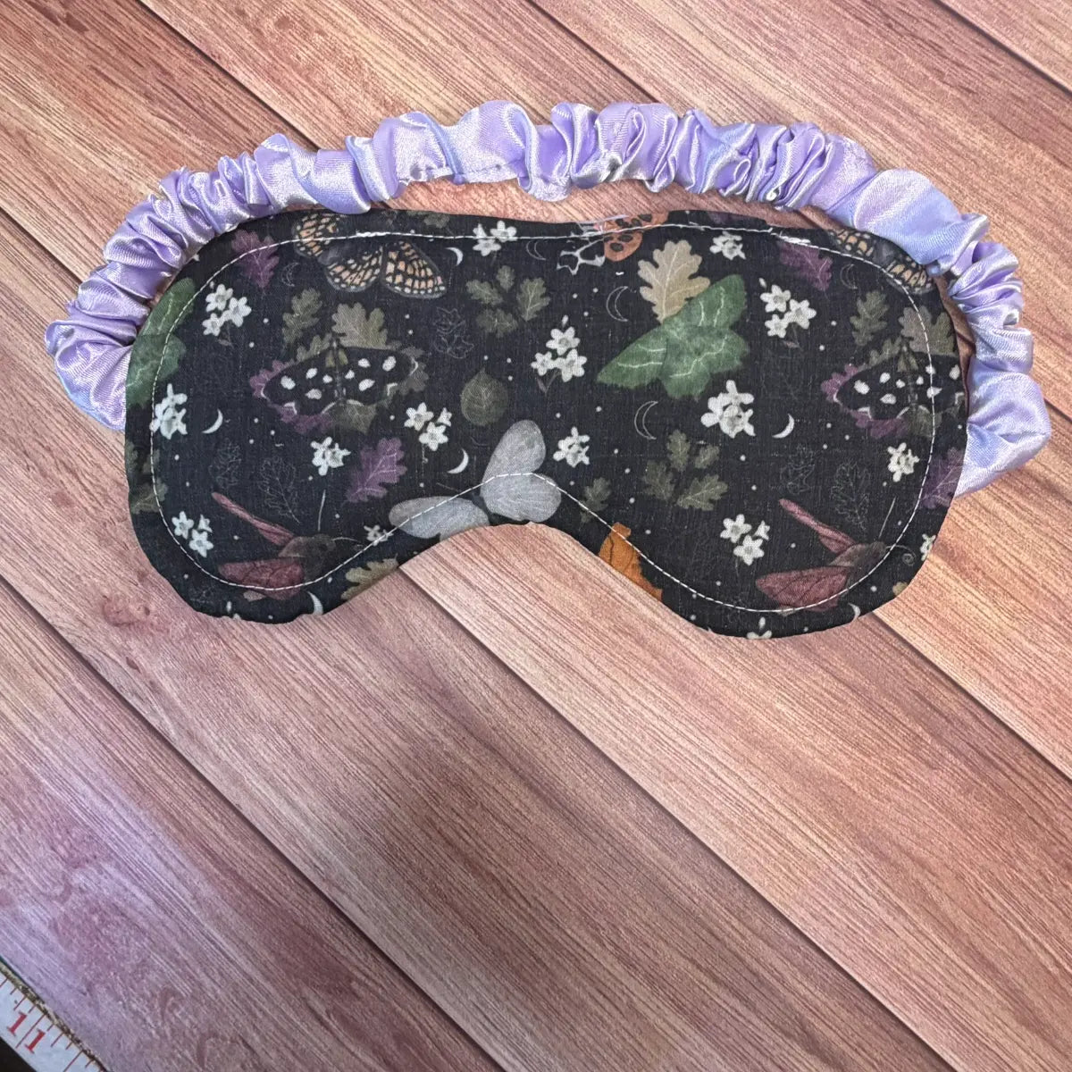 Insect-themed sleeping mask featuring detailed moth artwork, suitable as an unusual sleep present.
