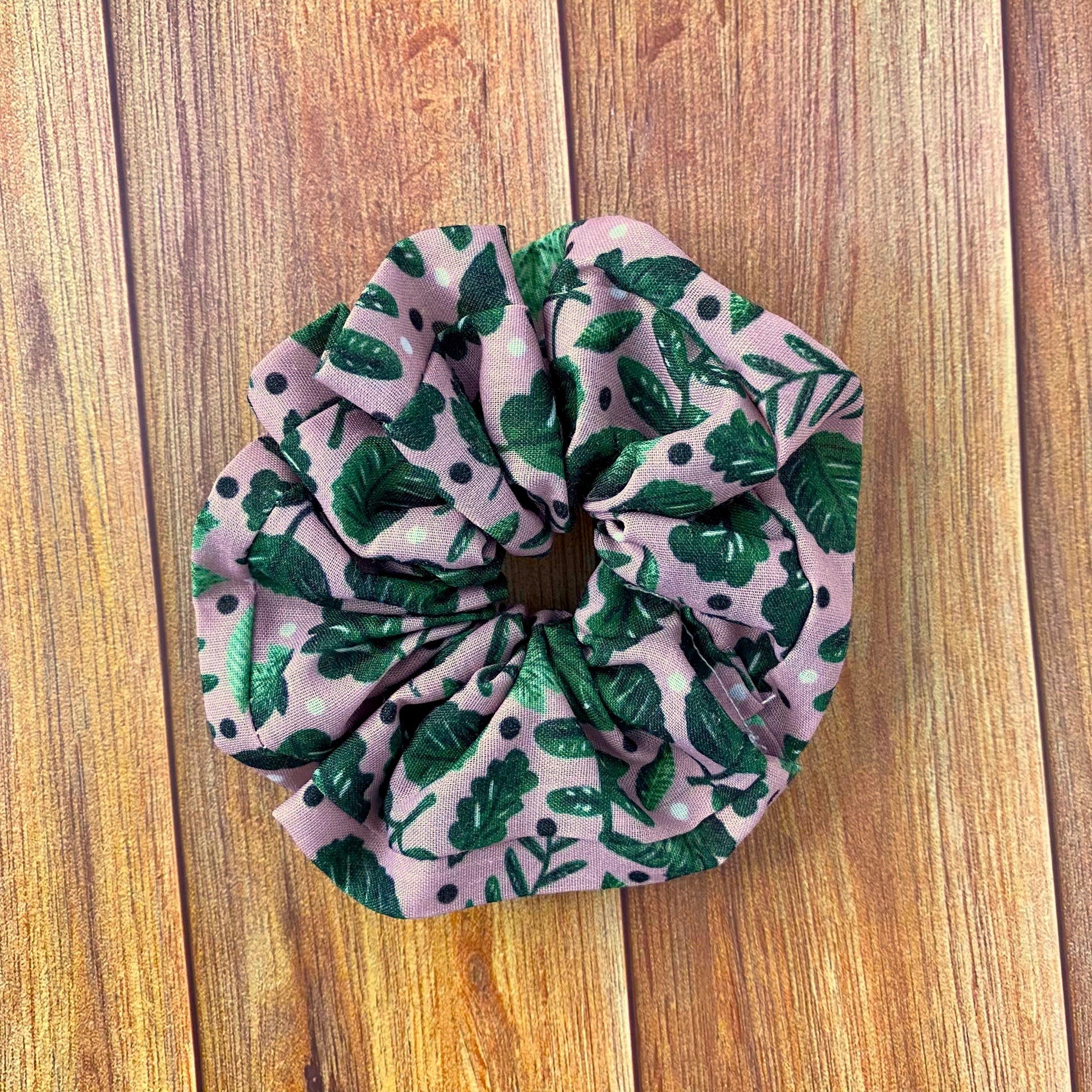 green foliage patterned scrunchie on wooden backdrop