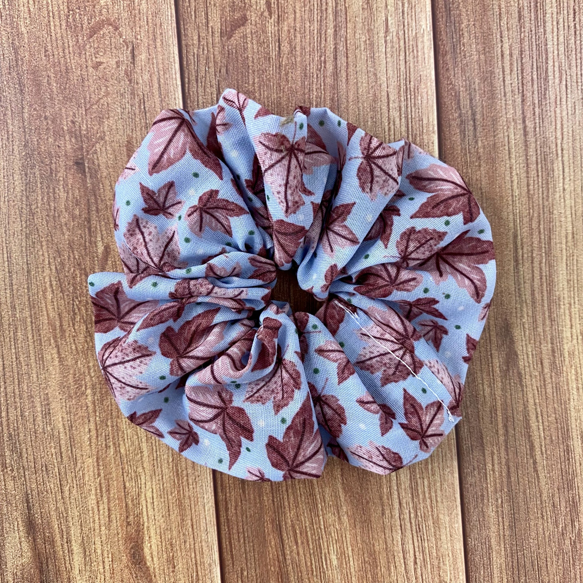 pink leafy patterned scrunchie on wooden surface 
