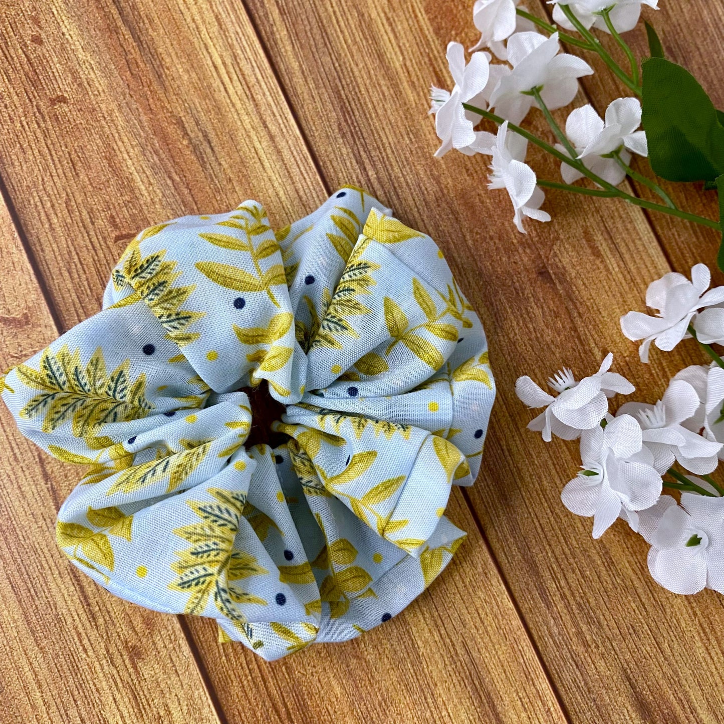 yellow foliage patterned scrunchie on wood