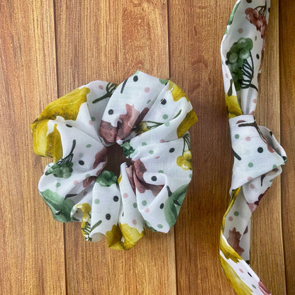 photograph of the scrunchie and headband of the hair accessories giftset on the wooden backdrop