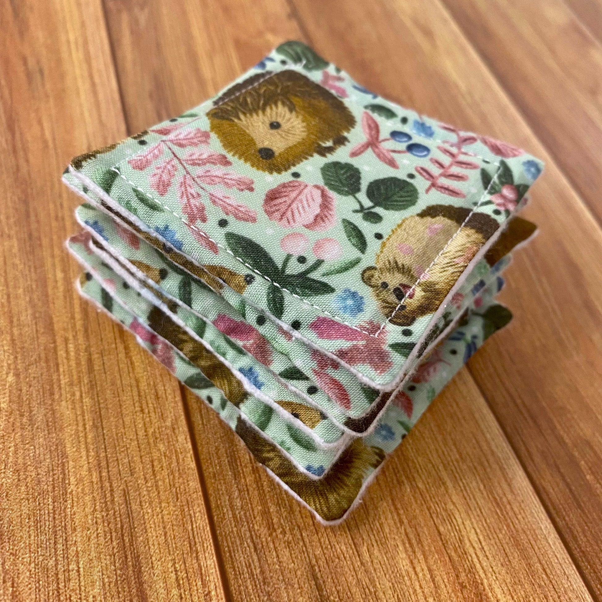 Stack of hedgehog patterned skincare pads on a wooden background
