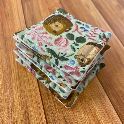reusable skincare pads on wooden background with hedgehog pattern on them