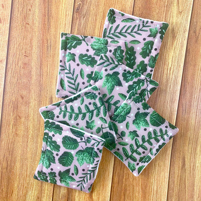 Green foliage patterned reusable makeup removal pads on a wooden background