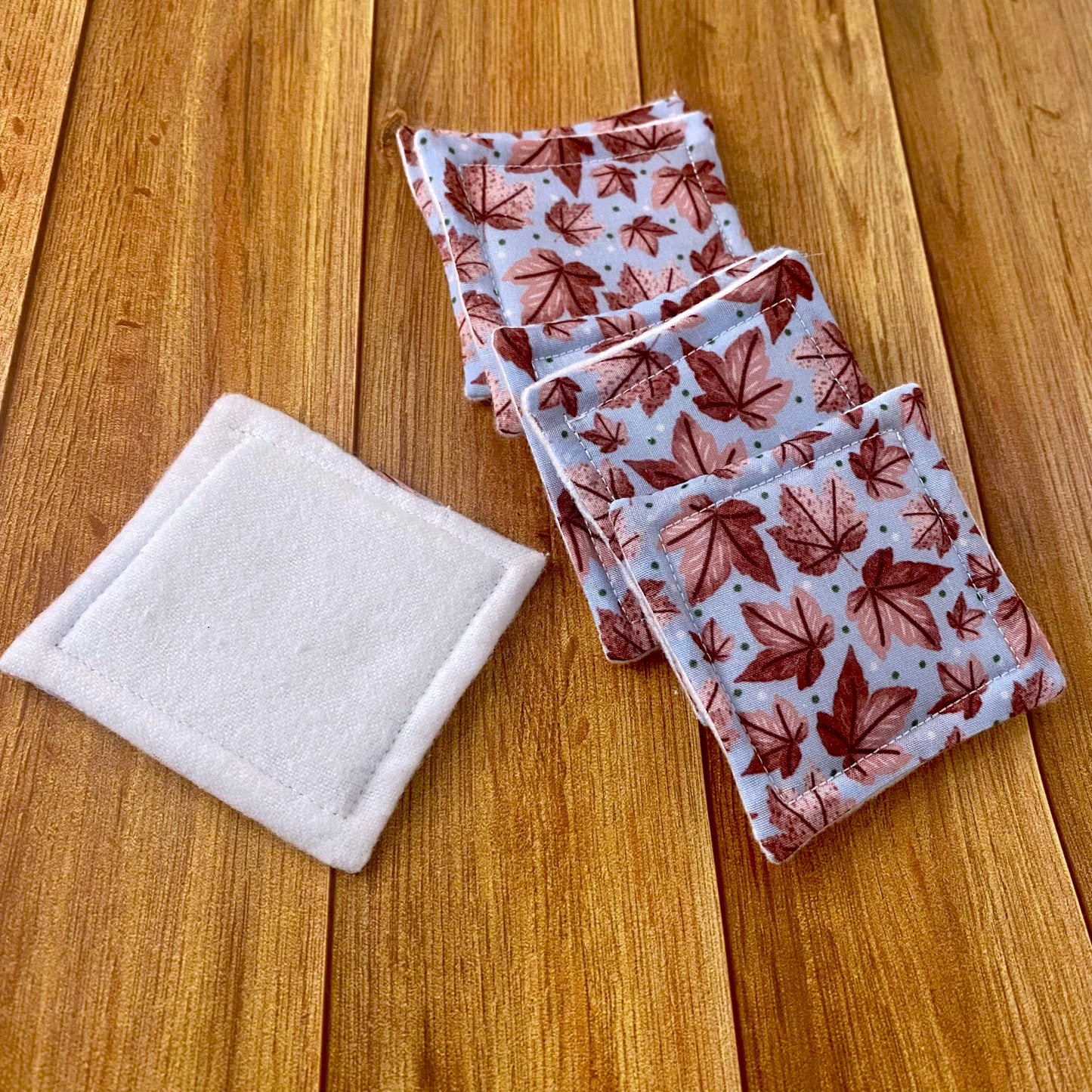 reusable skincare pads in pink leafy pattern on wood backdrop