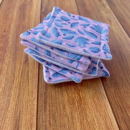 six reusable skincare pads in a pile showing the blue foliage surface pattern design on a wooden background