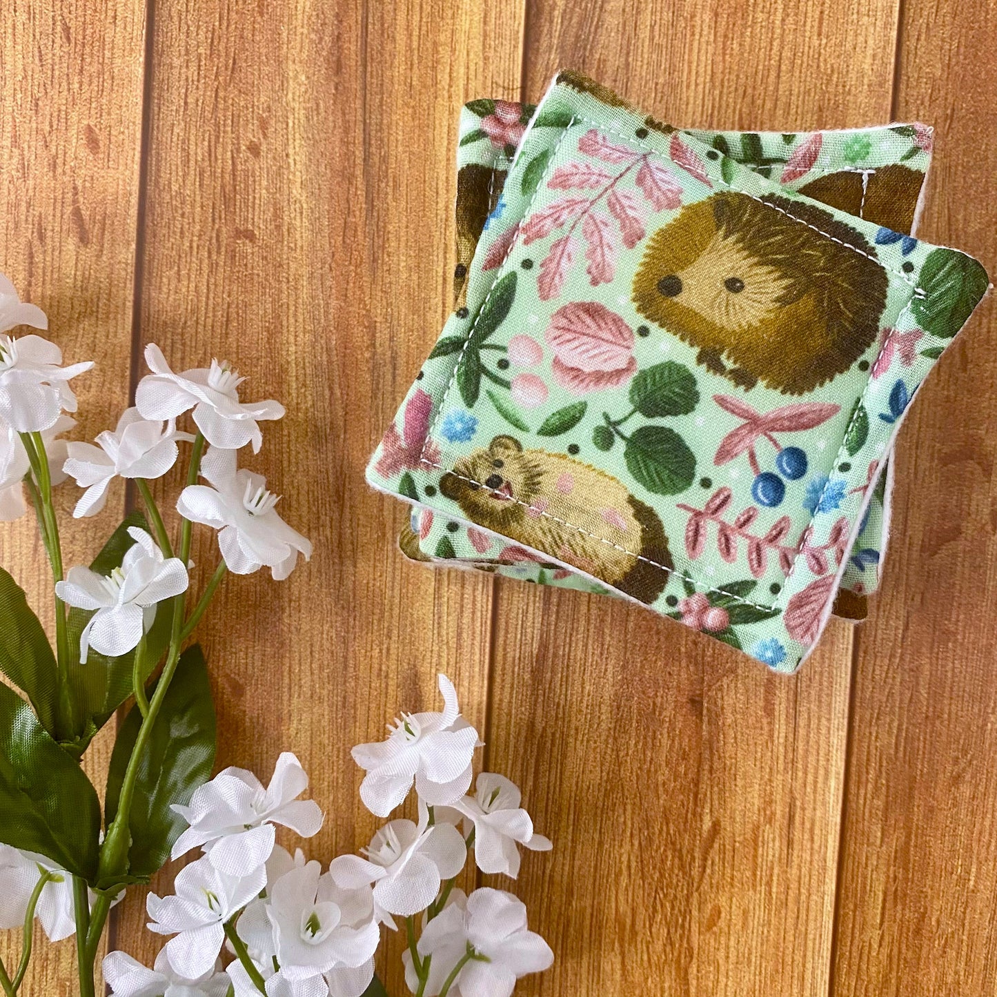 reusable skincare pads with hedgehog pattern on wood surface
