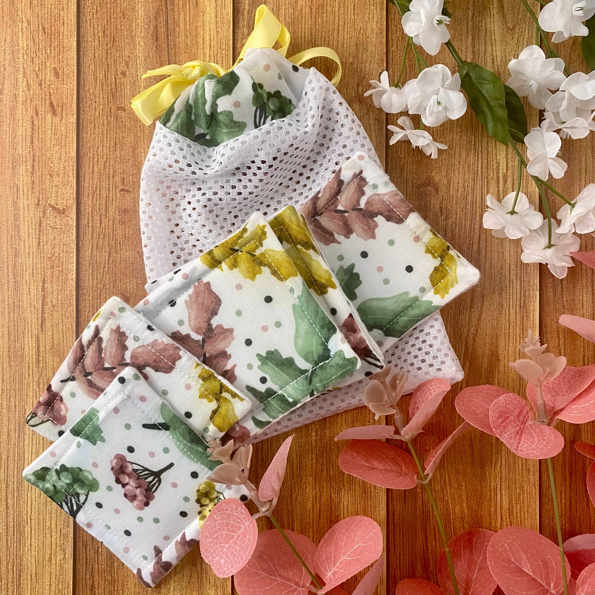pretty foliage patterned reusable skincare pads and washbag on wooden background