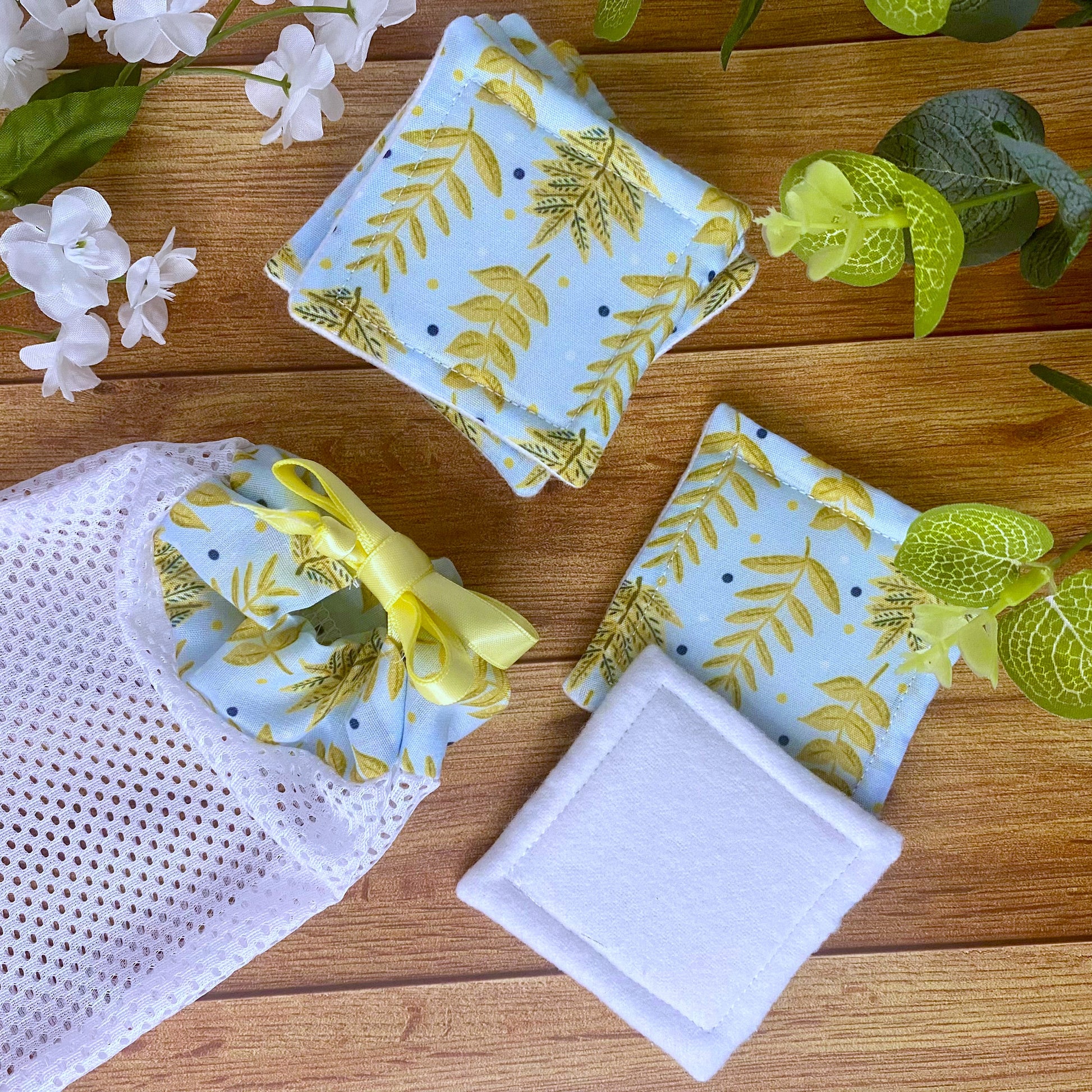 yellow foliage patterned skincare pads and washbag on wooden surface