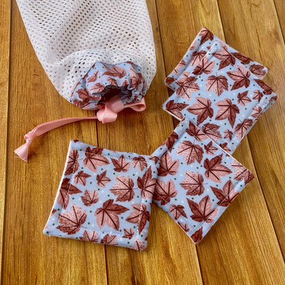 reusable skincare pads and washbag on wooden surface