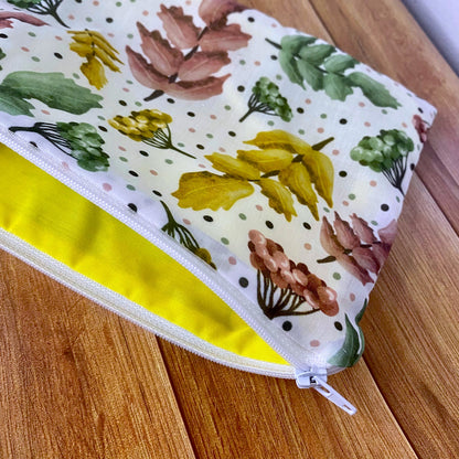 Closeup of the pretty foliage patterned pouch showing the yellow lining, ideal for a makeup lover as a makeup bag gift for holding skincare, makeup or more.