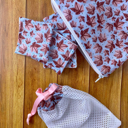 reusable skincare pads, pouch and washbag in pink leafy pattern design on a wooden surface