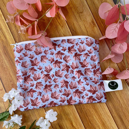 pink leafy patterned pouch on wooden background