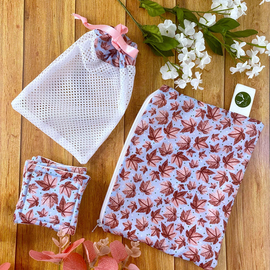 pink leafy patterned giftset including pouch, washbag and reusable skincare pads on a wooden background