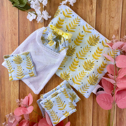 yellow foliage patterned pouch, skincare pads and washbag giftset on wood surface