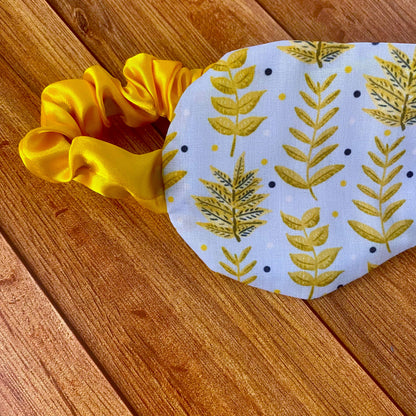 closeup of yellow foliage patterned sleepmask with yellow sati  strap