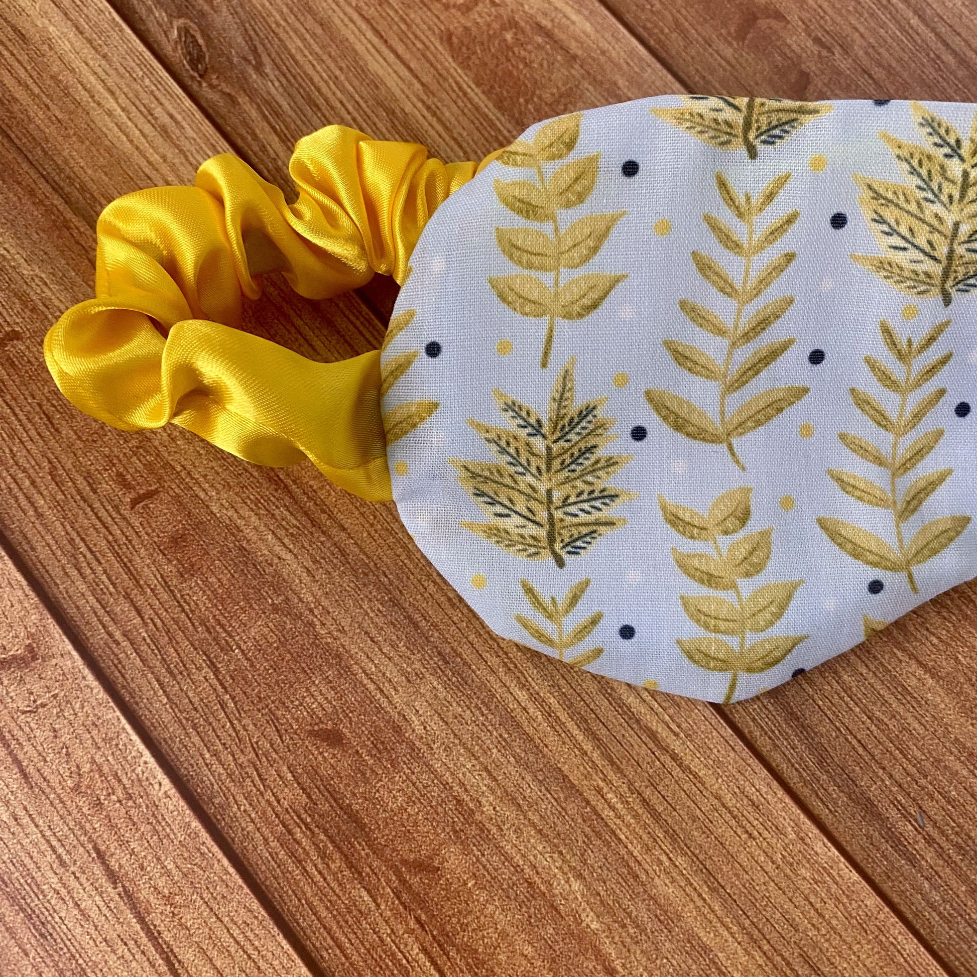 closeup of sleepmask with yellow foliage pattern on it