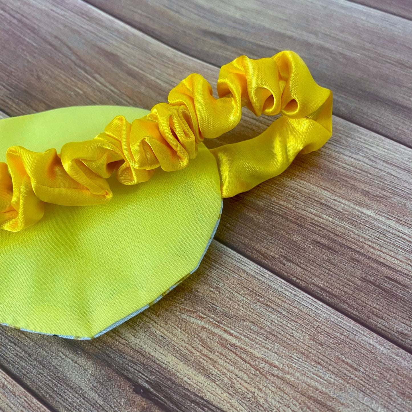 closeup of back of sleepmask showing yellow backing and yellow satin strap