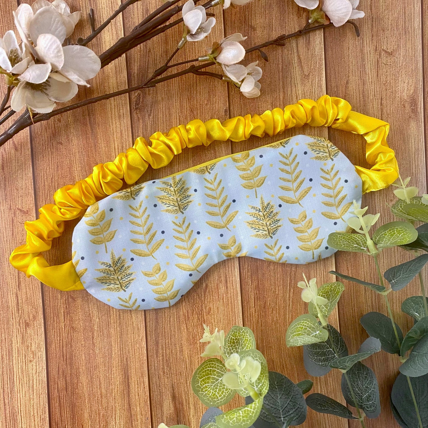 yellow foliage patterned sleepmask on a wooden backdrop
