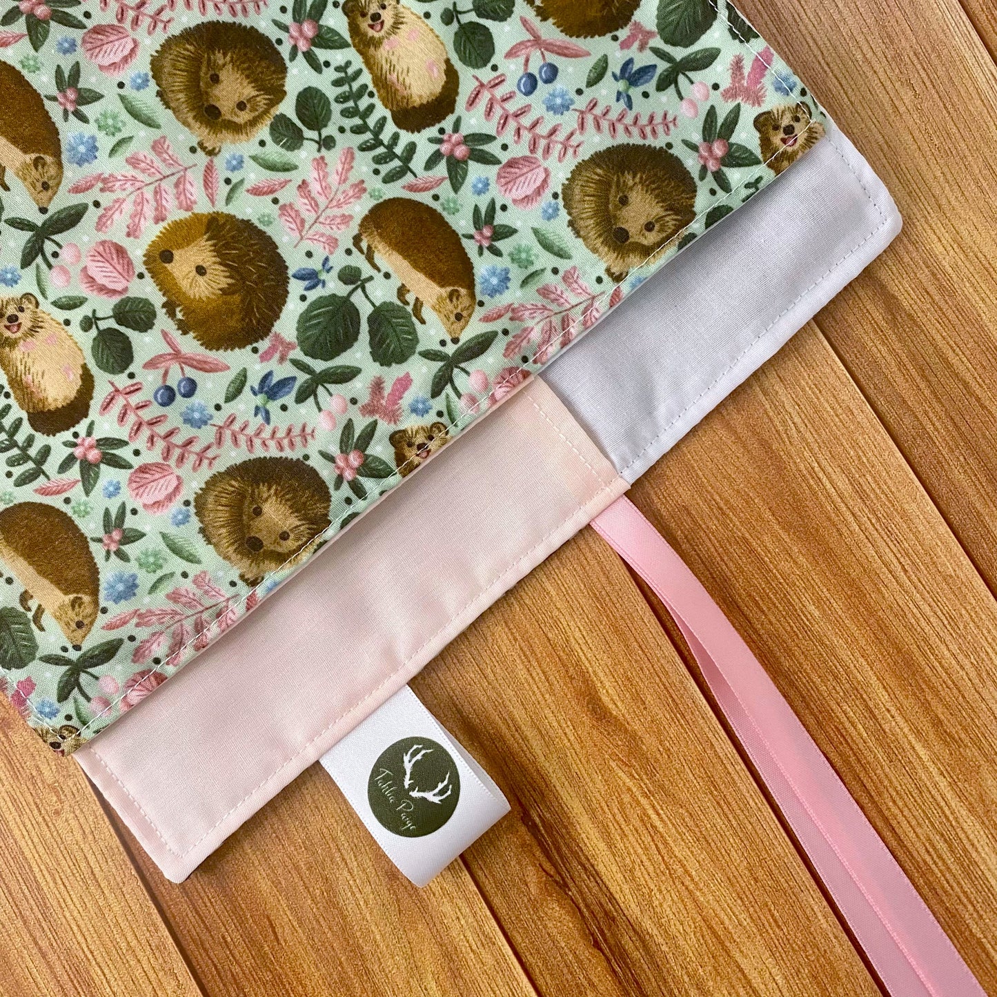 An ideal hedgehog gift for a hedgehog lover, this closeup shows the hedgehog pattern of the roll up brush roll and the ribbon to close it.