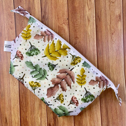 pretty foliage patterned makeup bag lying flat on a wooden background