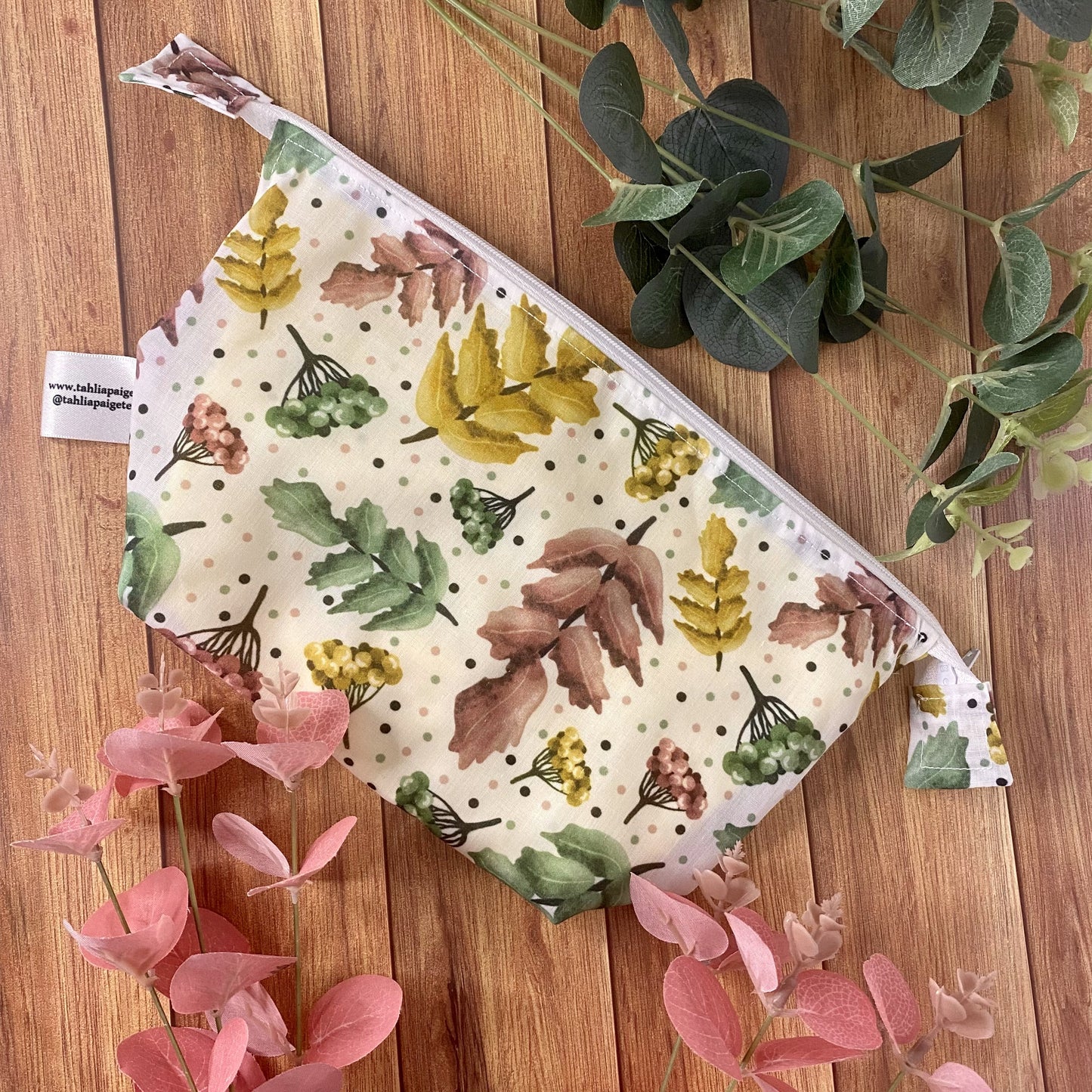pretty foliage patterned makeup bag on wooden background