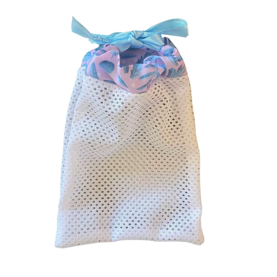 white mesh washbag with a blue and pink foliage pattern along the top of it, on a white background