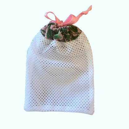 green foliage patterned washbag with pink ribbon sealing it at the top, designed to go with the reusable skincare pads