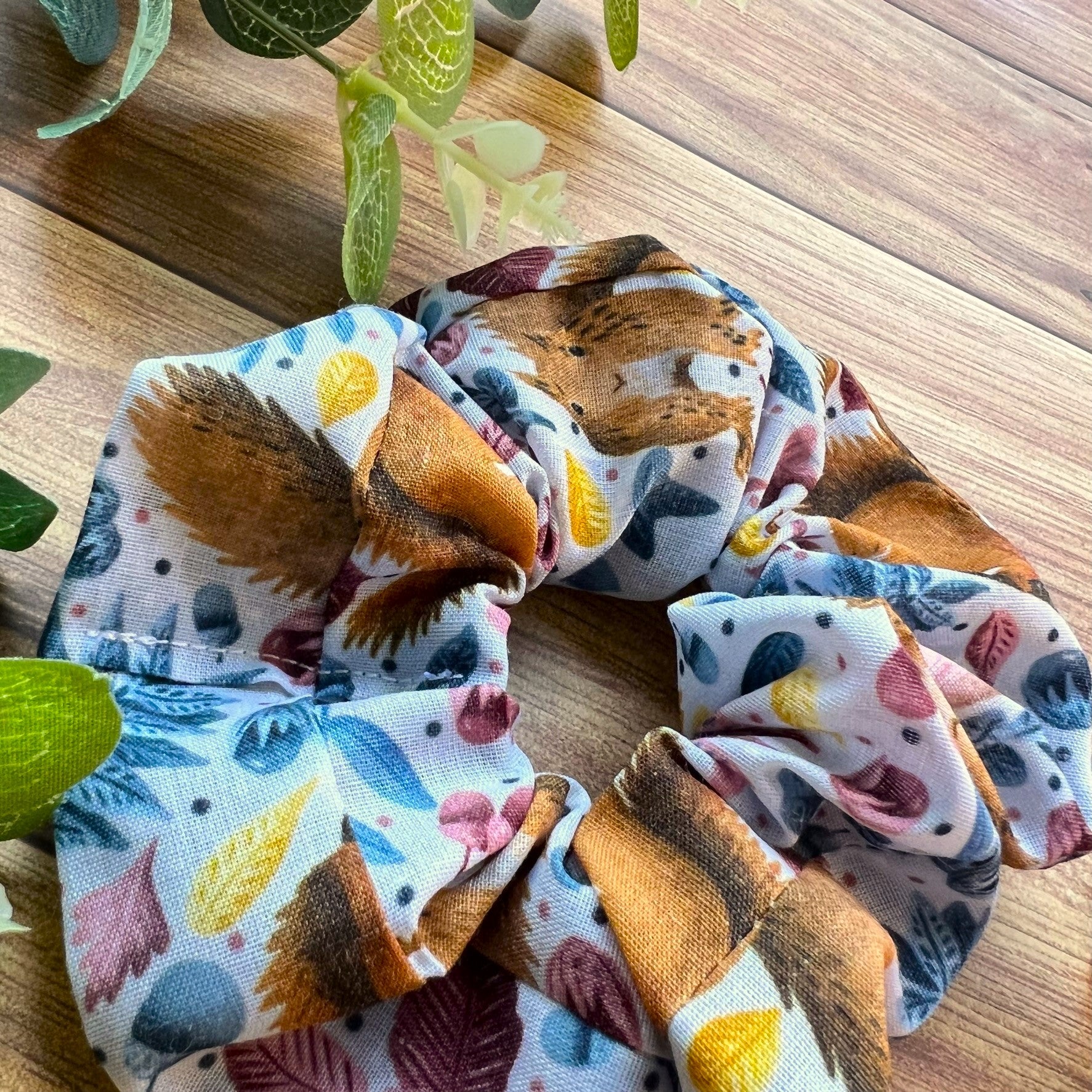 red squirrel patterned blue scrunchie closeup with wooden backdrop