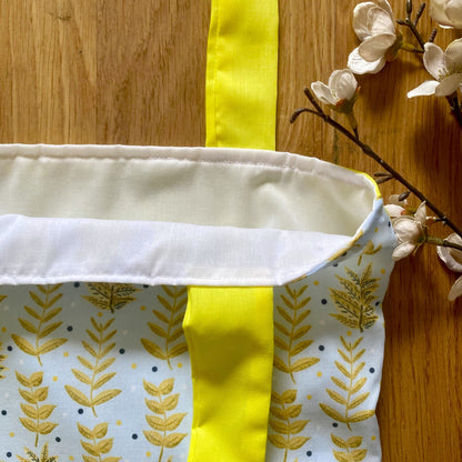 closeup of yellow foliage reusable shopping bag with white lining showing